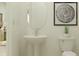 Clean, simple bathroom with a pedestal sink, toilet, and modern lighting at 4923 Southern Valley Loop, Brooksville, FL 34601