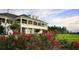 Expansive home featuring a grand veranda, lush landscaping, and vibrant roses in a well-manicured lawn at 4923 Southern Valley Loop, Brooksville, FL 34601