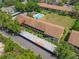 A high-angle aerial view showing building 30 surrounded by mature trees, green spaces, and a pool at 4991 Puritan Cir # 522, Tampa, FL 33617