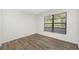 Bedroom with a large window with blinds and wood-look flooring at 4991 Puritan Cir # 522, Tampa, FL 33617