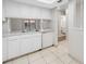 Bright kitchen with white appliances and cabinets plus an open serving space and tile flooring at 4991 Puritan Cir # 522, Tampa, FL 33617