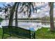 Lovely lake view from the bench, featuring calm water and trees draped with spanish moss at 4991 Puritan Cir # 522, Tampa, FL 33617