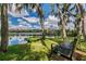 Enjoy a tranquil scene of lake with a park bench under shady trees draped with Spanish moss at 4991 Puritan Cir # 522, Tampa, FL 33617