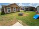 Expansive backyard with a trampoline, play structure, and lush green grass, offering plenty of space for recreation at 518 Greg St, Valrico, FL 33594