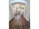 Inviting hallway showcases beautiful dark wood floors, white trim, and archways to the kitchen and dining areas at 518 Greg St, Valrico, FL 33594