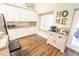 Charming kitchen with white cabinets, granite countertops, a window seat, and hardwood floors at 518 Greg St, Valrico, FL 33594