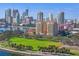 Aerial view showcasing the condo building, lush green park, bay, and the cityscape skyline at 555 5Th Ne Ave # 424, St Petersburg, FL 33701