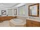 Luxurious bathroom featuring double sinks, large tub, wooden cabinets, vanity, and tile floor at 555 5Th Ne Ave # 424, St Petersburg, FL 33701