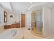 Bright bathroom featuring a soaking tub, separate shower with gold trim, and a large vanity with storage at 555 5Th Ne Ave # 424, St Petersburg, FL 33701