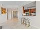 Elegant hallway with tile flooring, leading to kitchen featuring counter seating and wood cabinetry at 555 5Th Ne Ave # 424, St Petersburg, FL 33701