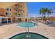 Condo pool and jacuzzi with deck chairs, palm trees, and a view of the condo complex at 555 5Th Ne Ave # 424, St Petersburg, FL 33701