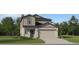 Charming two-story home with a manicured lawn and a two-car garage at 5623 Red Kite Dr, Wimauma, FL 33598