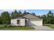 Charming single-story home featuring stucco siding, a two-car garage, and well-maintained landscaping at 5632 Red Kite Dr, Wimauma, FL 33598
