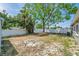 Spacious backyard featuring an open area surrounded by lush trees, green grass, and a privacy fence at 5660 Hobson Ne St, St Petersburg, FL 33703