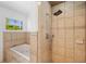 Bathroom with a shower and soaking tub featuring tiled walls, and a window that brings in natural light at 5660 Hobson Ne St, St Petersburg, FL 33703