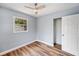 Bright bedroom with wood flooring, a ceiling fan, a window, and closet perfect for storage at 5660 Hobson Ne St, St Petersburg, FL 33703