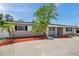 Inviting single-story home featuring beautiful landscaping, palm trees and a well-maintained front yard at 5660 Hobson Ne St, St Petersburg, FL 33703