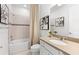 Bright bathroom featuring a shower-tub combo, neutral tile, and a modern vanity with a stone countertop at 5703 Silverside Pine Ct, Lakewood Ranch, FL 34211