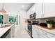 Contemporary kitchen with quartz countertops, stainless appliances, and tile backsplash at 5703 Silverside Pine Ct, Lakewood Ranch, FL 34211
