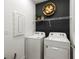 Practical laundry room including a washer, dryer, and storage shelving for added convenience at 5703 Silverside Pine Ct, Lakewood Ranch, FL 34211
