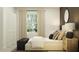 Bright bedroom featuring a dark accent wall, a full-length mirror, and neutral-toned bedding at 5709 Yellow Hornbill Ave, Wimauma, FL 33598
