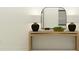 Modern hallway table with lamps and decorative mirror against a neutral wall color at 5709 Yellow Hornbill Ave, Wimauma, FL 33598