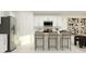 Bright kitchen with stainless steel appliances, white cabinetry, and bar stool seating at the kitchen island at 5709 Yellow Hornbill Ave, Wimauma, FL 33598