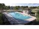 Large community pool with lounge chairs and umbrellas, offering a refreshing oasis for relaxation and recreation at 5709 Yellow Hornbill Ave, Wimauma, FL 33598