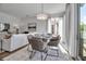 Open-concept living/dining area features modern decor, dining table, and adjacent living room with a white couch at 600 3Rd S Ave # 201, St Petersburg, FL 33701