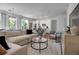 Open concept living room with white sofas, modern furniture, and kitchen in background at 600 3Rd S Ave # 201, St Petersburg, FL 33701