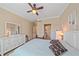 This bright bedroom features neutral walls, a ceiling fan and an ensuite bathroom through the doorway at 600 Gardens Edge Dr # 614, Venice, FL 34285