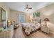 This bright bedroom has tropical themed decor with a palm tree painting, and a wall mounted television at 600 Gardens Edge Dr # 614, Venice, FL 34285