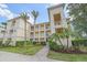 A well-maintained condo building with manicured landscaping and palm trees at 600 Gardens Edge Dr # 614, Venice, FL 34285
