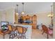 Bright kitchen showcases wood cabinetry, granite countertops, stylish pendant lighting, and seating at the bar at 600 Gardens Edge Dr # 614, Venice, FL 34285