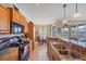 Well-equipped kitchen with black appliances, granite countertops, and views into the dining area at 600 Gardens Edge Dr # 614, Venice, FL 34285