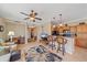 Open-concept living room featuring a ceiling fan, tile flooring, and an adjacent kitchen bar for easy entertaining at 600 Gardens Edge Dr # 614, Venice, FL 34285