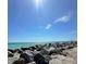 View of the blue ocean with a rock breakwater under a sunny blue sky at 600 Gardens Edge Dr # 614, Venice, FL 34285