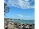 Scenic ocean view with rocks, buildings, and clear skies, a perfect vacation spot at 600 Gardens Edge Dr # 614, Venice, FL 34285