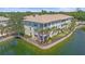 Rear view of a condo featuring a screened lanai overlooking a scenic pond with lush landscaping at 600 Gardens Edge Dr # 614, Venice, FL 34285