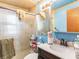 Cozy bathroom with shower, white sink, storage, and light blue paint at 705 E Alabama St, Plant City, FL 33563