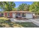Charming brick home featuring a well-kept front yard and an attached single-car garage at 705 E Alabama St, Plant City, FL 33563