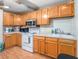 Cozy kitchen featuring wood cabinets, laminate countertop, an electric range, and laminate flooring at 705 E Alabama St, Plant City, FL 33563