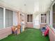 Inviting sunroom with green carpet, multiple windows, and a side entrance at 705 E Alabama St, Plant City, FL 33563