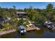 Waterfront home with private dock and boat lift surrounded by lush tropical foliage at 7508 N Ola Ave, Tampa, FL 33604