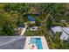 Aerial view of a waterfront property with a pool, dock, and lush tropical landscaping at 7508 N Ola Ave, Tampa, FL 33604