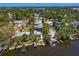 Wide aerial shot of a waterfront property featuring a pool, private dock, and mature trees at 7508 N Ola Ave, Tampa, FL 33604