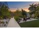 This backyard boasts an outdoor fireplace, artificial turf, travertine tile, and a wood walkway leading to the water at 7508 N Ola Ave, Tampa, FL 33604