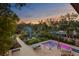The backyard features a pool, lush landscaping, and an outdoor seating area with a fire pit, perfect for entertaining at 7508 N Ola Ave, Tampa, FL 33604