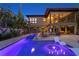 Backyard at dusk showcasing a modern pool and spa, lush landscaping, and the home's exterior at 7508 N Ola Ave, Tampa, FL 33604