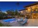 Backyard view with modern pool and spa, elegant seating, and manicured landscaping at twilight at 7508 N Ola Ave, Tampa, FL 33604